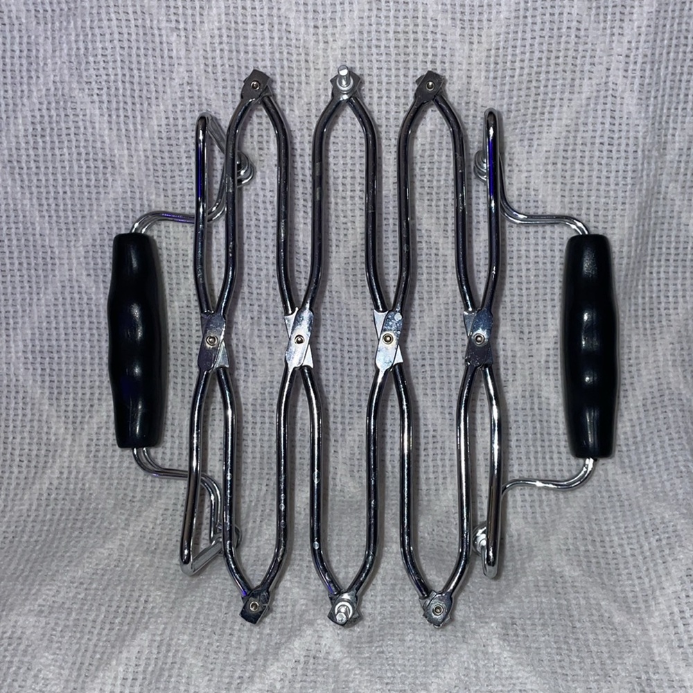 Expandable trivet with black rubber handles. - Picture 3 of 3